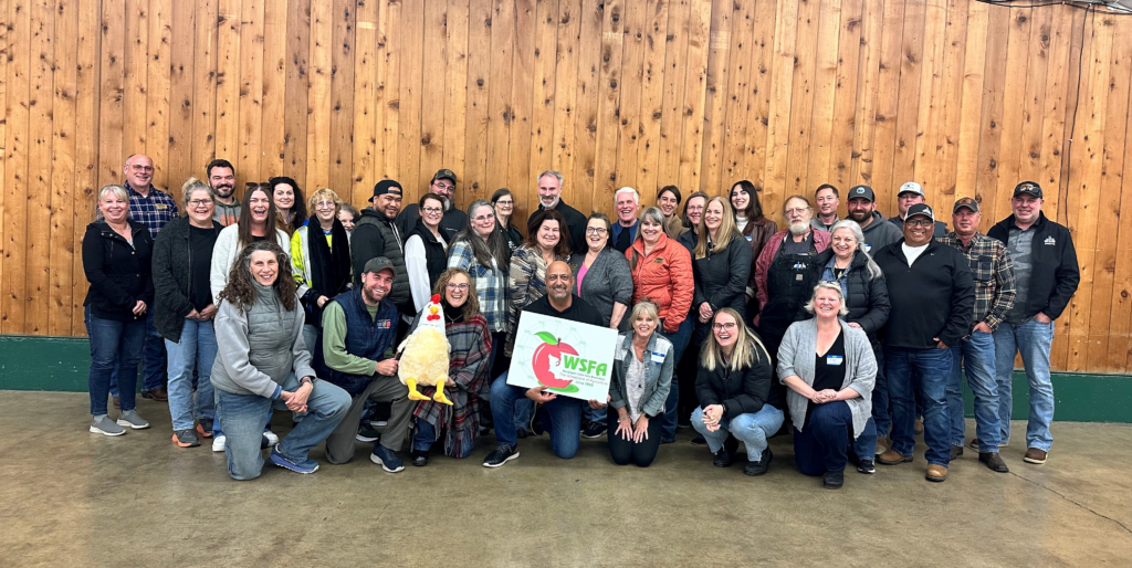 Group of You Make The Difference Washington participants standing together indoors, holding a Washington State sign, representing community collaboration and workforce advocacy.